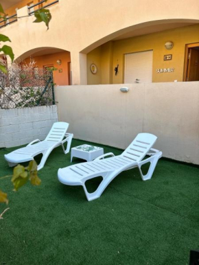 Bajo con jardín a pie de playa y piscina comunitaria con jacuzzi